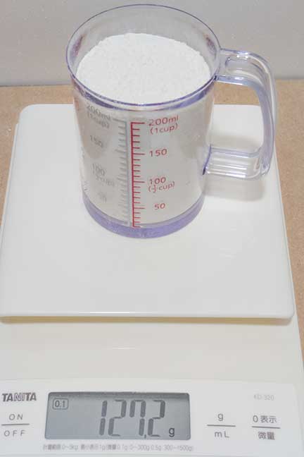 計量カップに127.2gの小麦粉